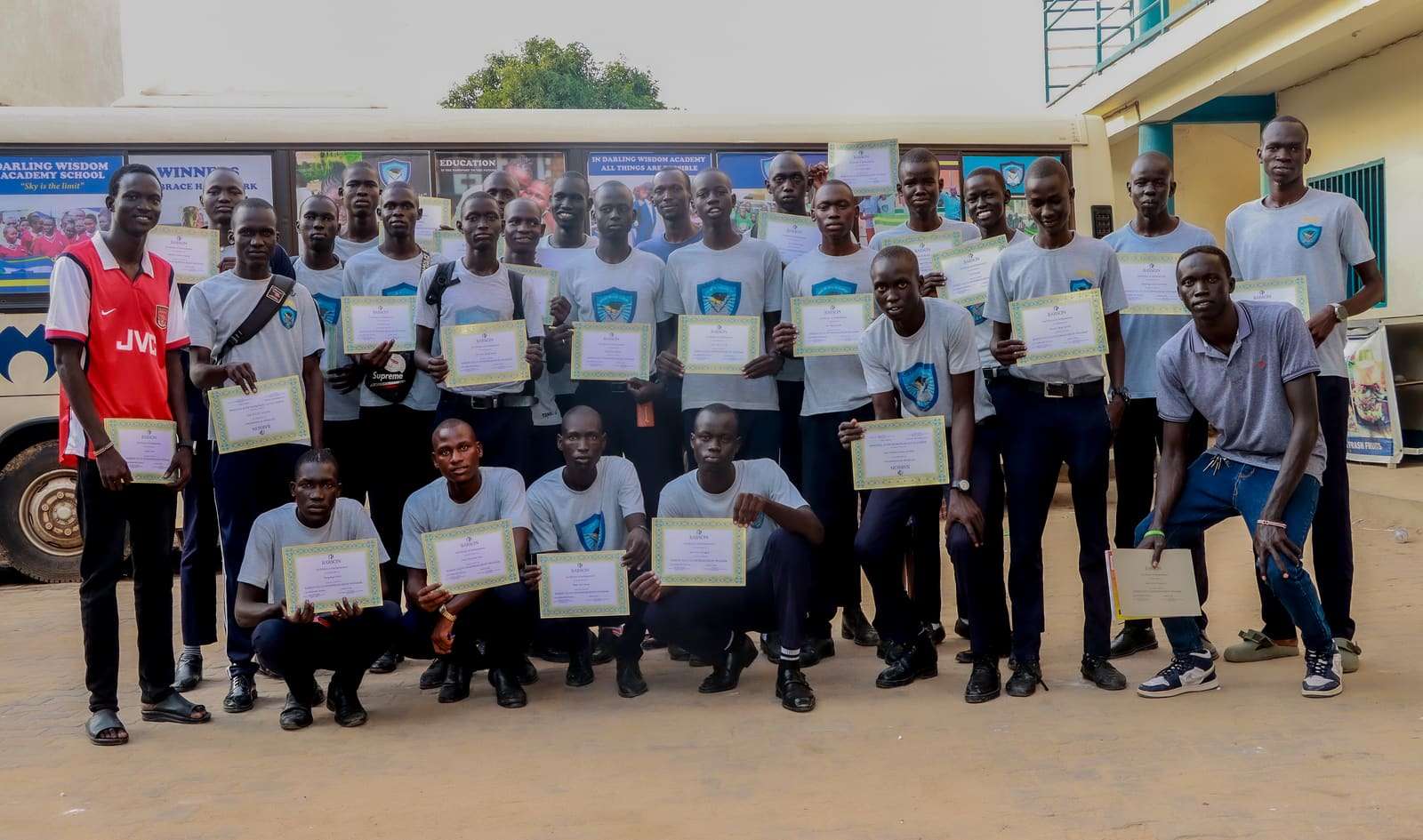 Young people holding their certificates in a group photo