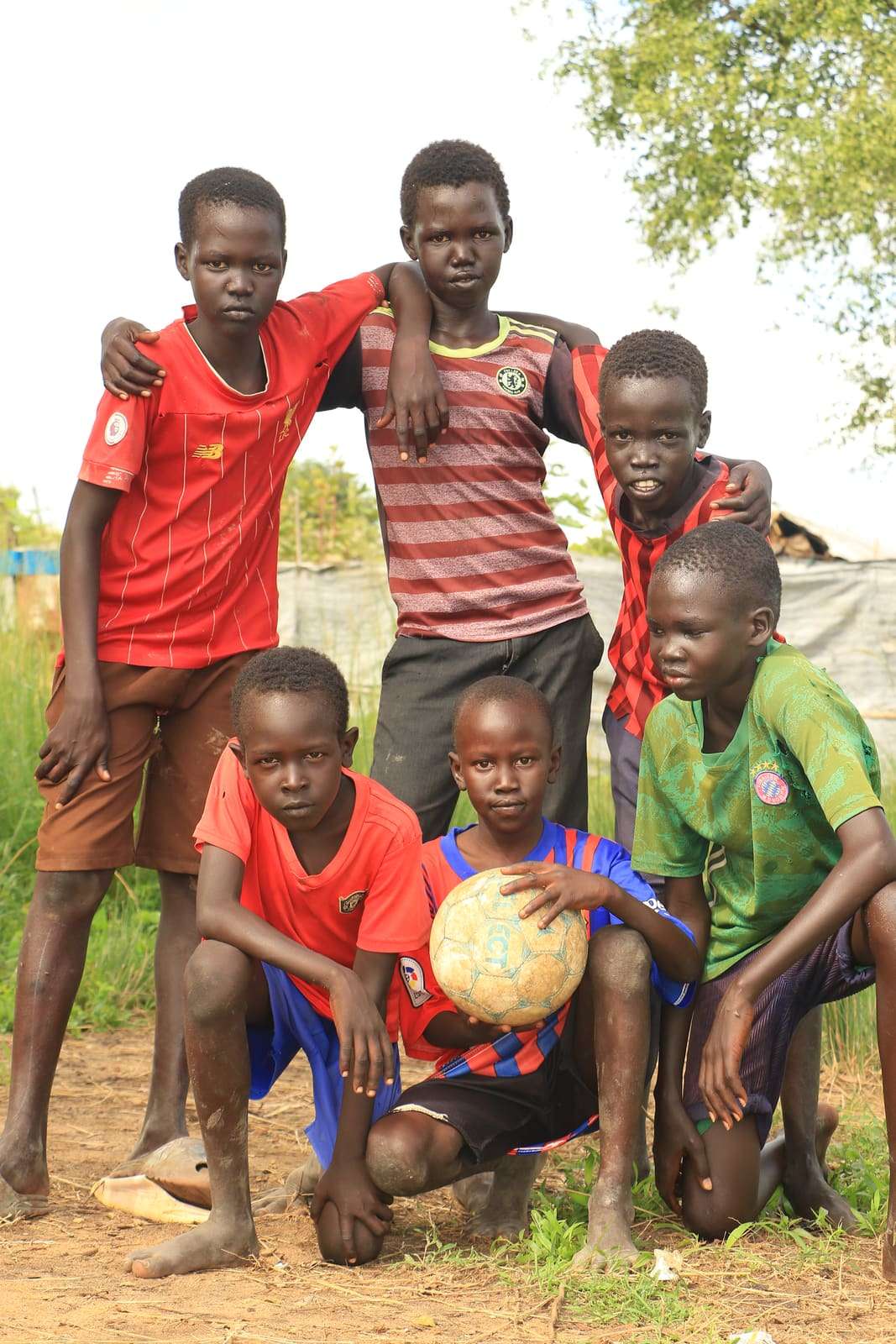 Young footballers posing with a worn football