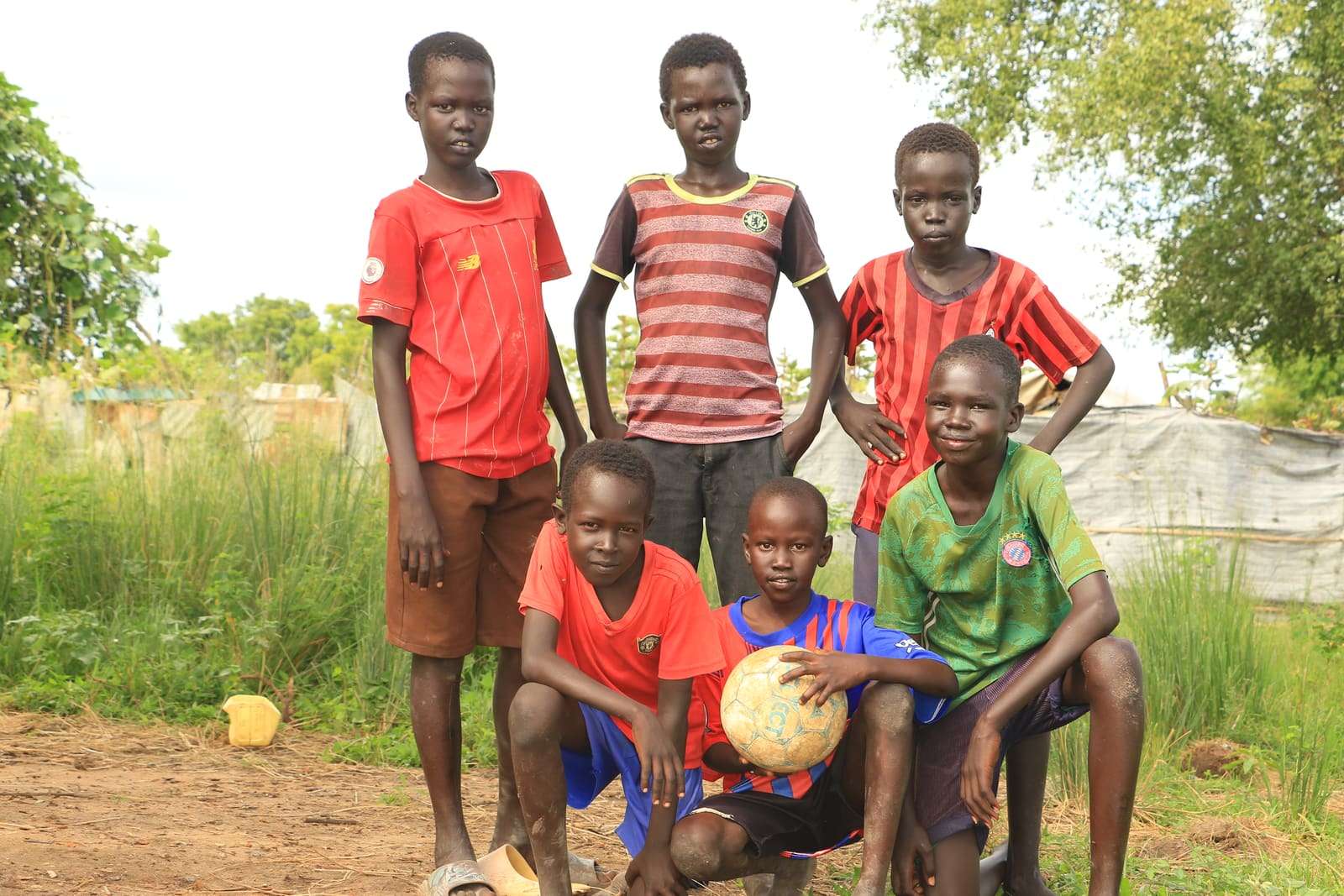Six young footballers with their ball